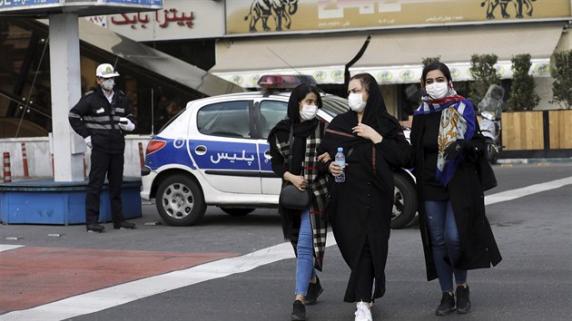 Íránky z Teheránu se chrání před nákazou koronavirem, který se v zemi v posledních dnech šíří. Roušku má také nedaleko stojící policista. (23. února 2020)