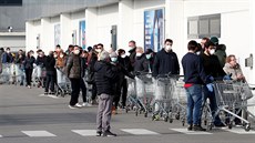 Lidé ekají ped supermarketem v uzaveném mst Casalpusterlengo v Lombardii....