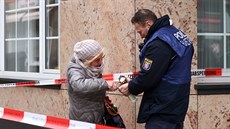 Policista pomáhá en zapálit svíku ped ia barem v nmeckém mst Hanau,...
