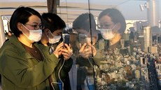 Návtvníci vyhlídkové budovy v Tokiu nosí ochranné masky. (24. února 2020)