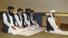 Delegace afghánského radikálního hnutí Talibán se modlí ped podpisem mírové...