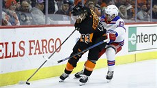 Jakub Voráek z Philadelphie (vlevo) u puku, brání ho Adam Fox z NY Rangers.