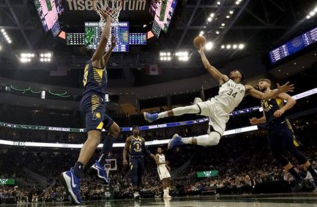 Faulovaný Janis Adetokunbo z Milwaukee zakonuje v akrobatické pozici v utkání...