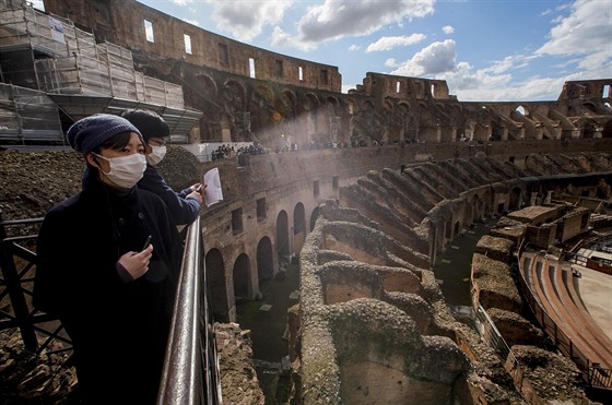 Turisté s roukami si prohlíí ímské Koloseum (7. 3. 2020).