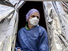 Zdravotnice s nasazenou ochrannou maskou ve stanu zízeném italskou civilní...