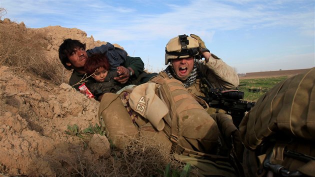 Americk marik se spolu s afghnskmi civilisty kryje ped neptelskou palbou v provincii Hlmand. (13. nora 2010)