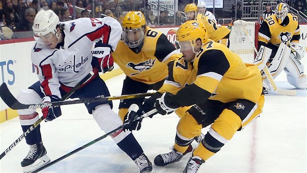 T.J. Oshie z Washingtonu si kryje puk ped Johnem Marinem (6) a Samem Laffiertym (37) z Pittsburghu.