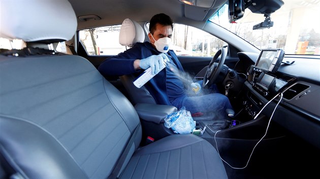 Italsk� taxik�� dezinfikuje sv� auto. Kv�li obav�m z n�kazy koronavirem nos� ochranou masku. (28. �nora 2020)
