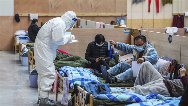 Doktor v ochrannm odvu kontroluje pacienty v doasn nemocnici ve Wu-chanu, kde vypukla epidemie covidu-19. (21. nora 2020)