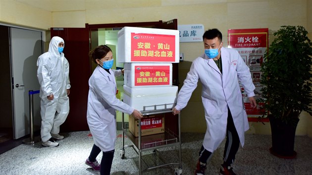Zdravotníci v ochranných rouškách převáží krevní testy v čínském Wu-chanu, kde vypukla epidemie koronaviru COVID-19. (2. března 2020)