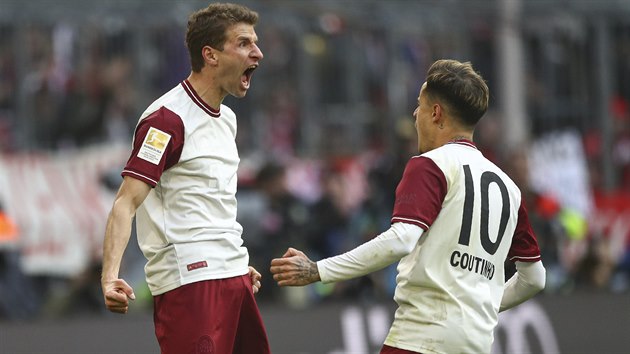 Thomas Mller v dresu Bayernu oslavuje se spoluhrem Philippe Coutinhem svou trefu do st Augsburgu.