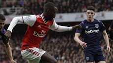 Nicolas Pepe z Arsenalu se snaí projít mezi bránícími hrái West Hamu.