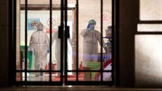 Zdravotníci v ochranných odvech uzavírají doasnou nemocnici v ínském...