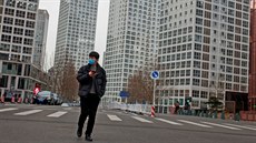 Muž se prochází opuštěnou byznys třídou v Pekingu. (2. března 2020)