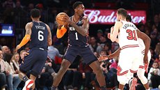 Tomá Satoranský z Chicaga pi obranné práci, u míe Bobby Portis z New York...