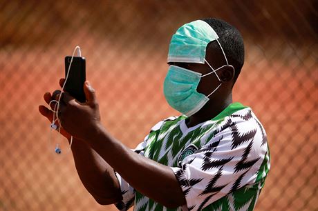 Mladý mu v ochranné rouce si fotí pátelské fotbalové utkání v nigerijské...