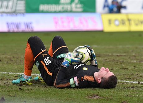 Zklamaný teplický branká Tomá Grigar leí na zbídaeném trávníku stadionu Na...