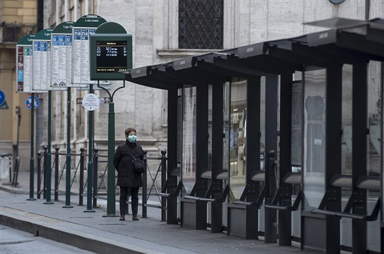 Osamělá žena čeká na autobusové zastávce v Římě na spoj. V Itálii platí pátým...