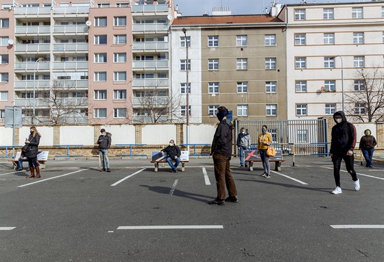 Lidé v rozestupech čekají před výdejnou obchodu Alza v pražských Holešovicích....