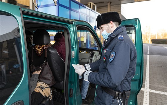 Maarský policista na hranicích s Ukrajinou kontroluje auto. Maarsko kvli...