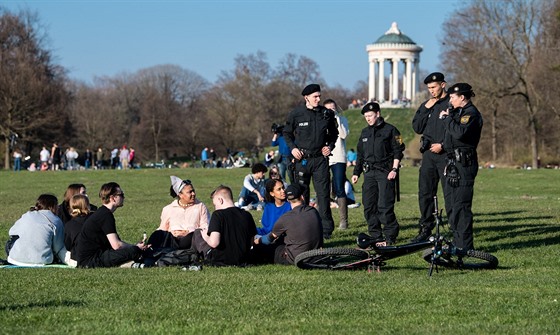 Mnichovští policisté upozorňují mladé lidi v parku, aby dodržovali dostatečný...