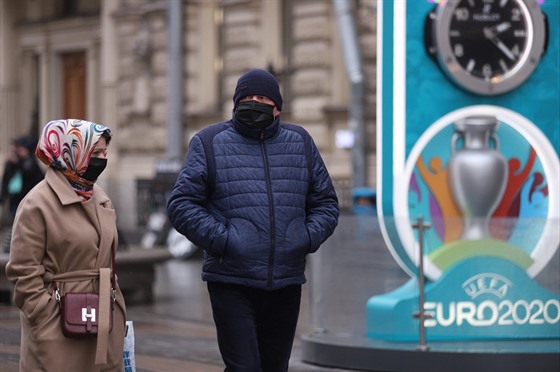 Lidé v ruském Petrohradu zahalení roukami procházejí kolem poutae na...