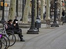 Lidé posedávají na lavice v Barcelon. (15. bezna 2020)
