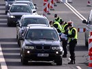 Čeští policisté a celníci v respirátorech kontrolují na hraničním přechodu...