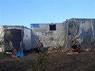 Migranti sedí u peplnného uprchlického tábora na eckém ostrov Lesbos. (11....