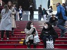 Japonské turistky s roukami na Times Square v New Yorku. Americký prezident...