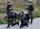 Izraeltí policisté nosí rouky proti koronaviru, zatímco sledují palestinský...