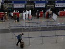 Lidé v ochranných roukách a odvech na letiti v Pekingu. ína nyní eviduje...