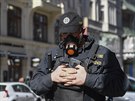 Policista hlídkuje se speciálním respirátorem v centru Prahy. (14. března 2020)