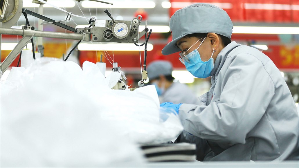 Pracovnice v čínské továrně na výrobu roušek a ochranných prostředků.