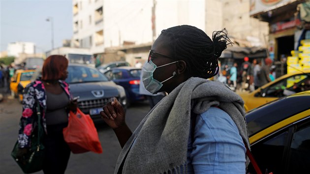 Lid v roukch prochzej po ulici v Dakaru, hlavnm mst Senegalu. (18. bezna 2020)
