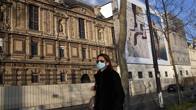 Žena v roušce se prochází na ulici v Paříži. (18. března 2020)