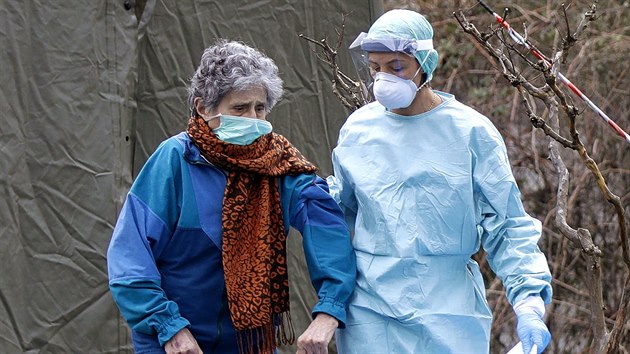 Zdravotnice pomáhá starší ženě v nemocnici Brescia na severu Itálie. (12. března 2020)