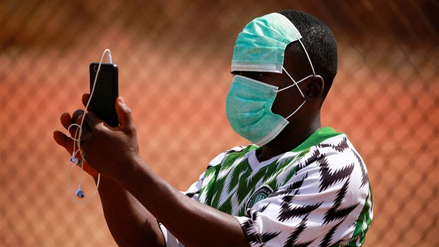 Mlad mu v ochrann rouce si fot ptelsk fotbalov utkn v nigerijsk metropoli Abuji. (5. bezna 2020)