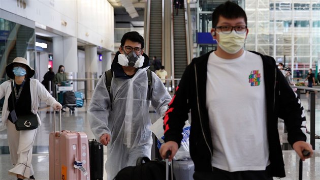 Cestujc z Londna nos ochrann odv proti koronaviru na mezinrodnm letiti v Hongkongu. (17. bezna 2020)