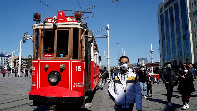 Lid na istanbulskm nmst Taksim se ped nkazou koronavirem chrn roukami a respirtory. (17. bezna 2020)