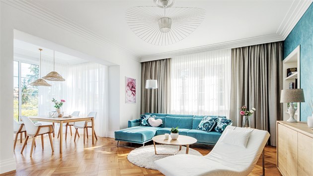 Noblesní dojem velkému obývacímu pokoji dodaly bílé stupňovité lišty pod stropem, které vyniknou i díky modré výmalbě stěn.