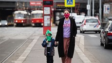 ena s díttem ekají na tramvajové zastávce v praských Nuslích. (17. bezna...