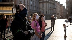 Turisté v roukách sledují orloj na Staromstském námstí v Praze. (18. bezna...