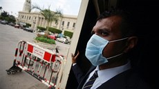 Pracovník ostrahy v Káhie se chrání respiraní roukou. (15. bezna 2020)