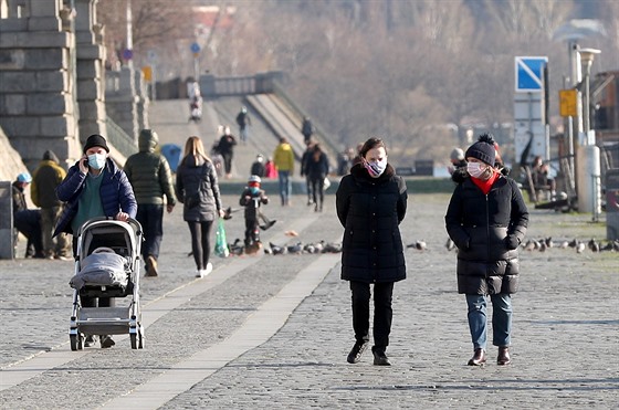 Lidé v roukách na náplavce v centru Prahy. (24. bezna 2020)