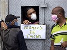 Lidé postávají u okénka lékárny ve venezuelském Caracasu. (24. bezna 2020)