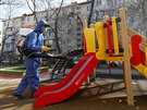 Muž dezinfikuje dětské hřiště v kazašském Almaty. (27. března 2020) 