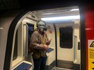 Mu s maskou proti koronaviru v londýnském metru. Britská vláda vyzvala obany,...