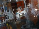Zdravotníci v ochranných odvech se starají o pacienta nakaeného koronavirem....