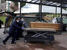 Zaměstnanci pohřební služby vezou do krematoria ostatky člověka nakaženého...